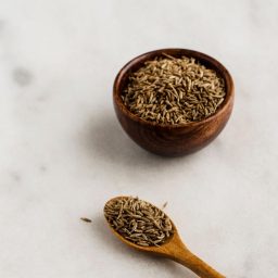 Kreuzkümmel in einer Schale und auf einem Holzlöffel